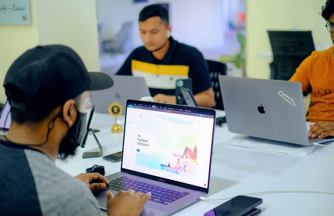 A polished workspace with a laptop and monitors showing design software.